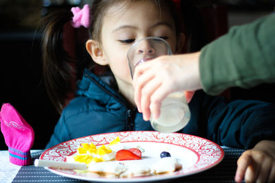 Midsection of girl holding ice cream in plate on table