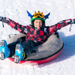 Portrait of happy boy sitting on snow