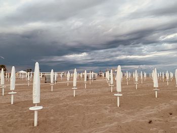 Wooden posts on beach against sky