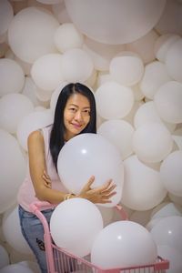 Portrait of a smiling young woman with balloons