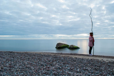 Rear view of two people overlooking calm sea