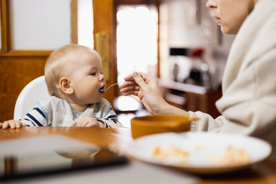 Portrait of cute boy eating food at home