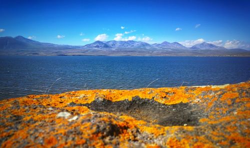 Scenic view of sea by mountains against sky