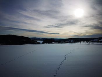 Scenic view of frozen lake against sky during sunset