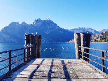 Scenic view of sea and mountains against clear blue sky