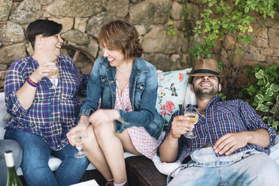 Happy friends enjoying drinks in yard