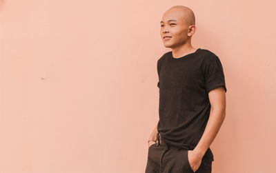 Young man looking away against white background