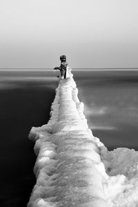 Snowcapped wooden posts in frozen baltic sea during winter
