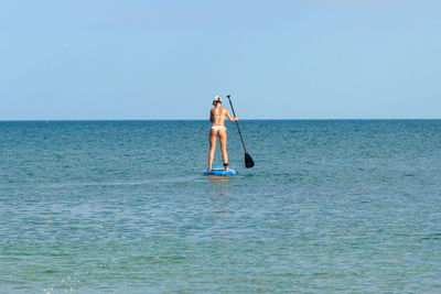 Man in sea against clear sky