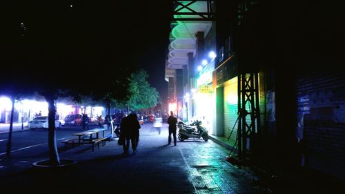 Man walking on illuminated road at night