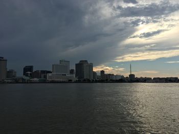 Sea by buildings against sky in city