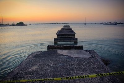 Pier on sea at sunset