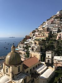 High angle view of positano townscape by sea against clear sky