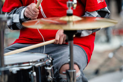 Midsection of man playing drum