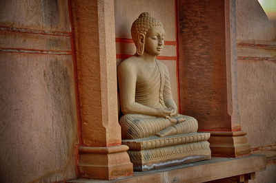 Statue of buddha against building