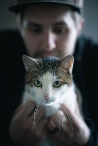 Close-up of young man holding cat