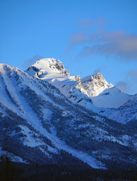 Scenic view of snowcapped mountains against blue sky