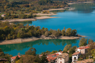 High angle view of lake amidst trees and buildings