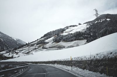 Road by mountains against sky