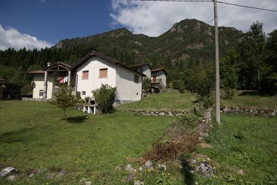 Houses by trees and buildings against sky