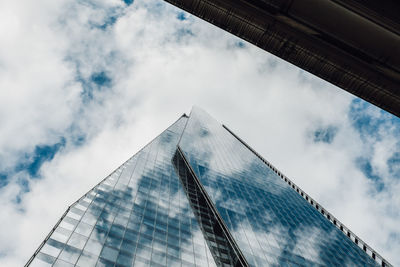 Low angle view of glass building against sky