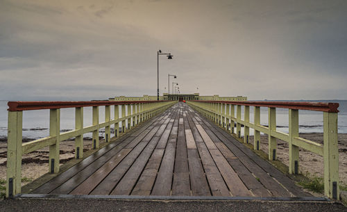Pier over sea against sky during sunset