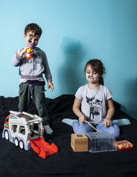 Cute boy sitting on toy against toys