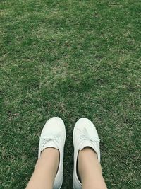 Low section of woman relaxing on grassy field