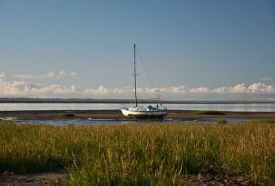 Sailboat moored on sea against sky