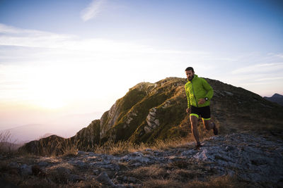 Italy, man running on mountain trail