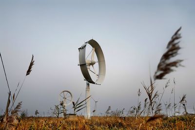 Windmills on field against sky