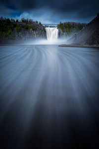 Scenic view of waterfall against sky