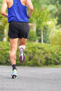 Low section of woman jogging on road