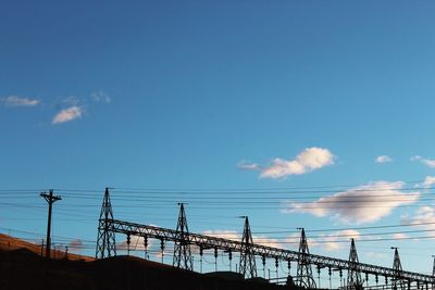 Low angle view of telephone pole against blue sky