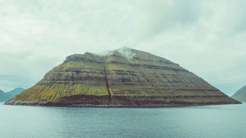 Scenic view of sea and mountain against sky