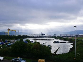 Cars on sea by city against sky