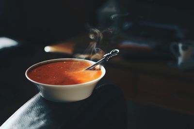 Tomato soup in bowl on sofa at home