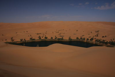 Scenic view of desert oasis against sky