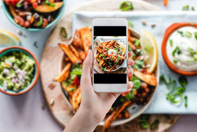Close-up of hand holding food served in plate