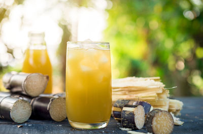 Close-up of sugar cane and juices on table