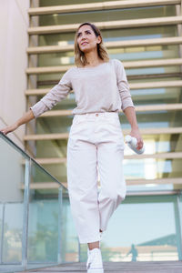 Portrait of young woman standing in city