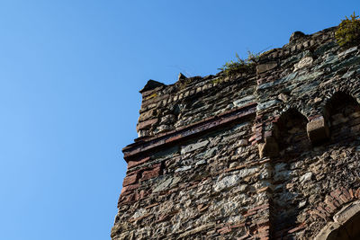Low angle view of old building against clear blue sky
