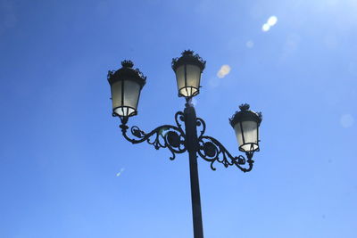 Low angle view of street light against blue sky