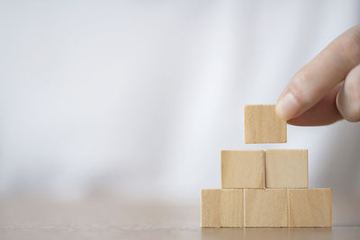 Close-up of hand holding wooden blocks on table