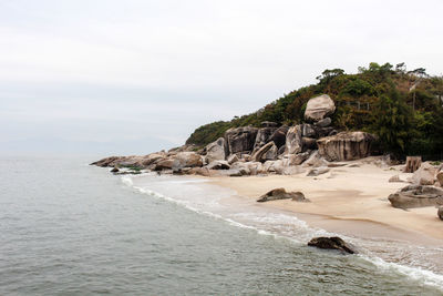 Scenic view of mountain by sea against sky