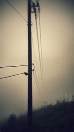 Low angle view of electricity pylon against sky