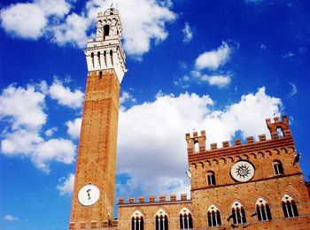 Low angle view of bell tower against cloudy sky