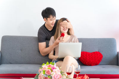 Young man using mobile phone while sitting on sofa