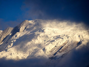 Low angle view of snowcapped mountains against sky