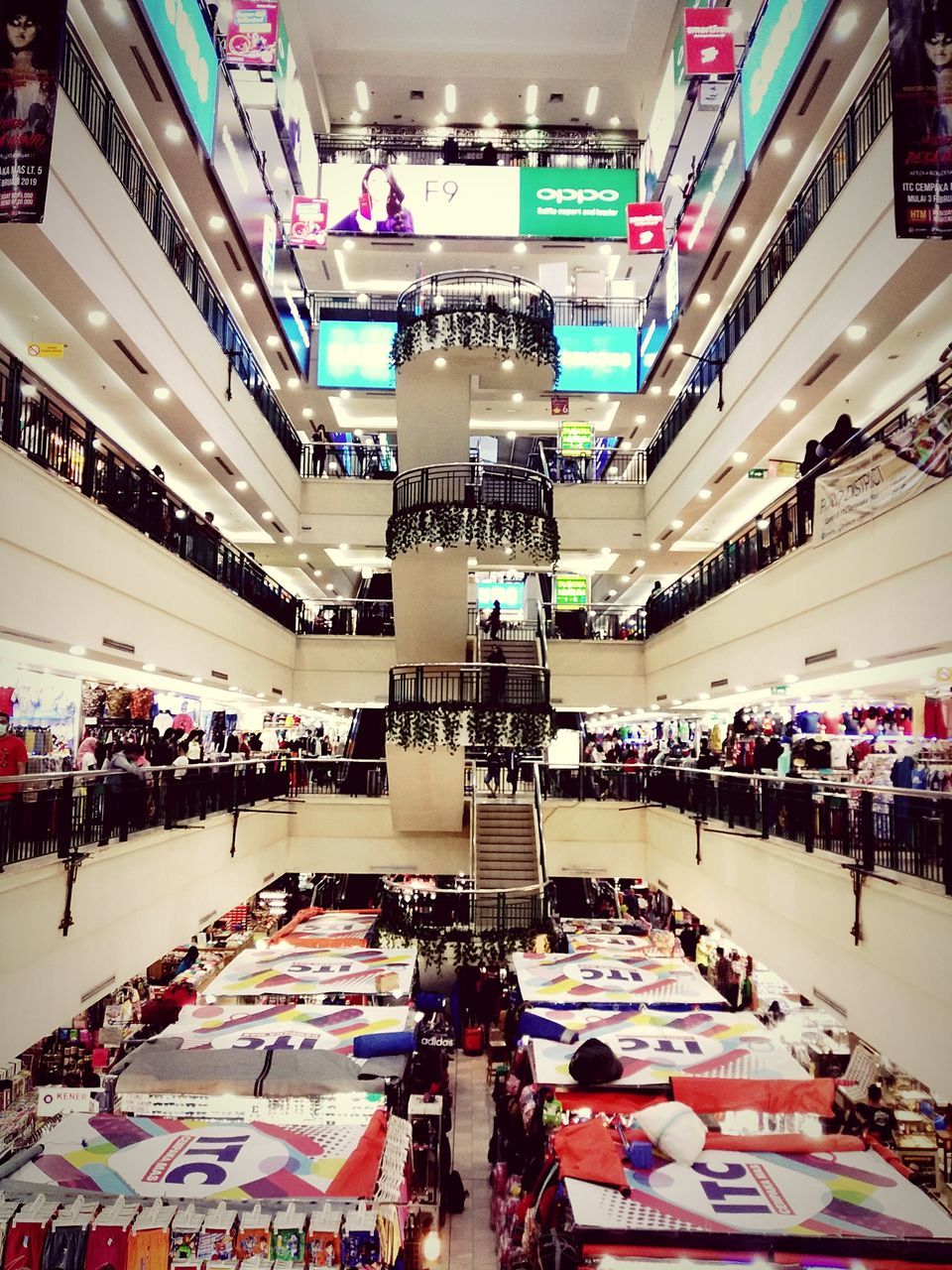 architecture, illuminated, incidental people, group of people, shopping mall, retail, large group of people, shopping, crowd, indoors, city, store, built structure, city life, real people, consumerism, transportation, modern, market, ceiling